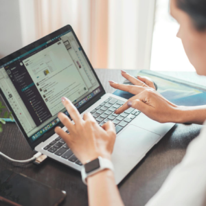 A woman working on a laptop from home, focusing on digital tasks and communication.