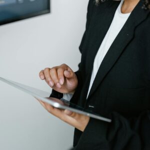 Professional woman interacts with a digital tablet in an office environment, showcasing technological engagement.